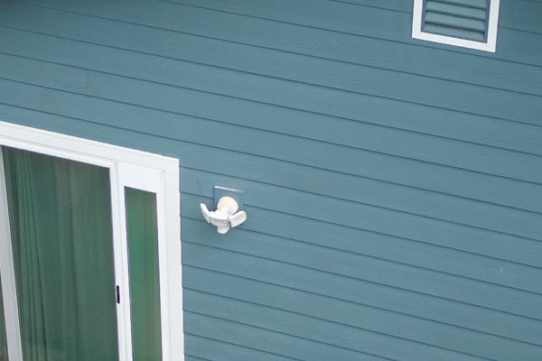 Evening Blue James Hardie siding with Arctic White trim on a home in Alameda, CA, featuring a landscaped patio