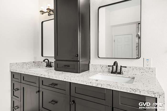 Modern double sink vanity with dark cabinetry, quartz countertop, and framed mirrors in remodeled Sacramento bathroom