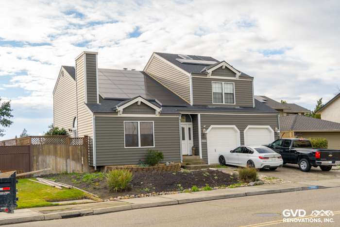 Freshly remodeled home exterior featuring Prodigy siding in dark gray with solar panels, captured from the street