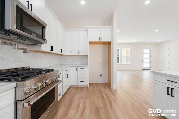 Modern kitchen featuring white shaker cabinets, stainless steel appliances, and marble backsplash in Paradise, CA