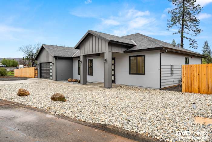 New construction home exterior in Paradise featuring James Hardie siding, Milgard black windows, and gravel landscaping