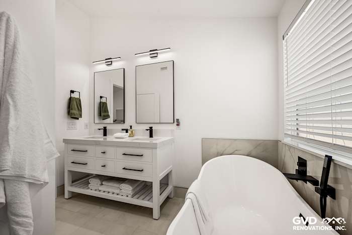 Bright modern bathroom featuring a dual vanity, freestanding tub, and large mirrors in Antelope, CA