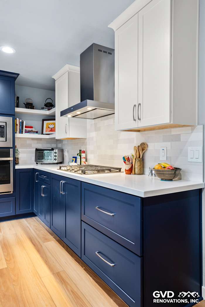 Modern kitchen with navy blue cabinetry, quartz countertops, stainless steel appliances, and tiled backsplash in Fair Oaks