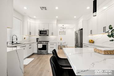Modern kitchen remodel in Antelope with quartz countertops, custom cabinets, stainless steel appliances, and stylish lighting