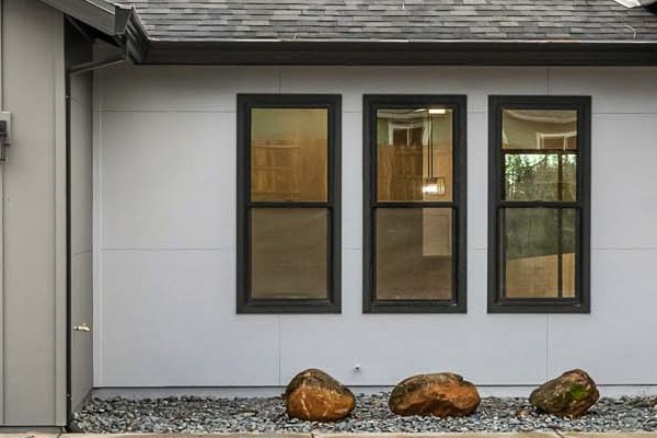Modern home exterior in Paradise, CA featuring James Hardie panels, Milgard windows, and gravel landscaping
