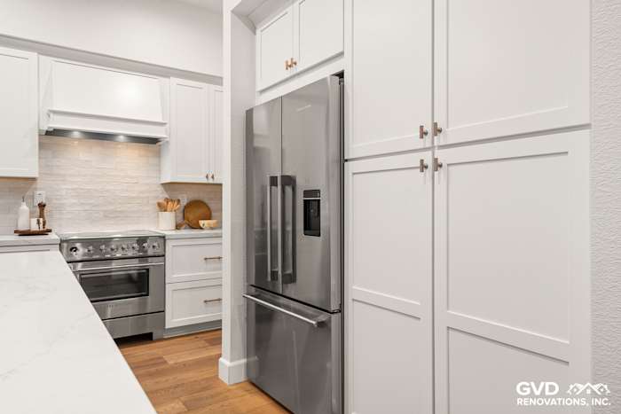 Sleek Folsom kitchen with white Waypoint cabinets, stainless steel appliances, and elegant mitered-edge countertop