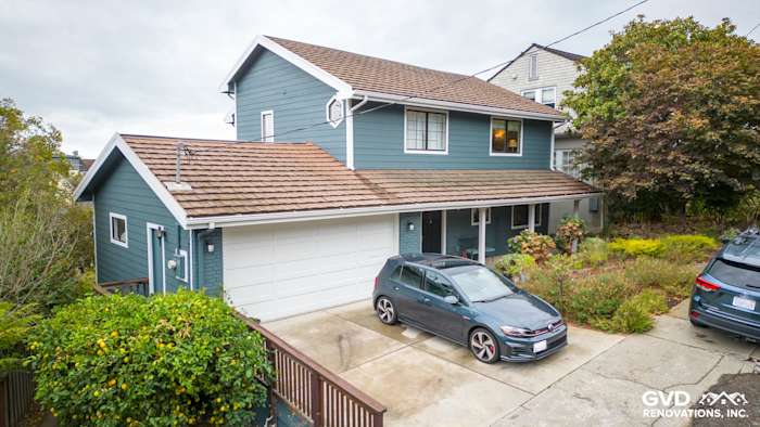 Oakland home exterior featuring Evening Blue HardiePlank siding and Rustic Grain Arctic White trim, with a landscaped
