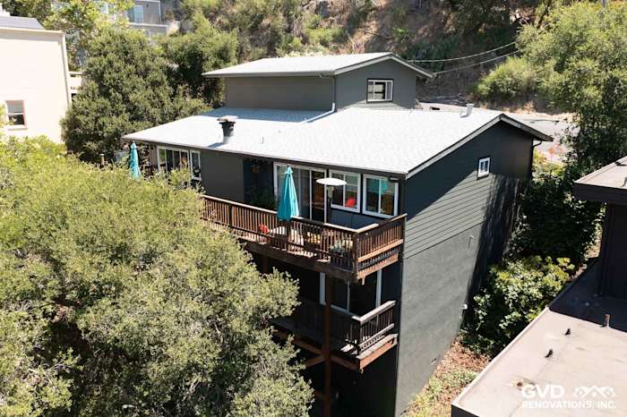 Oakland home exterior featuring Iron Gray James Hardie Lap Siding and a wooden deck with green umbrellas