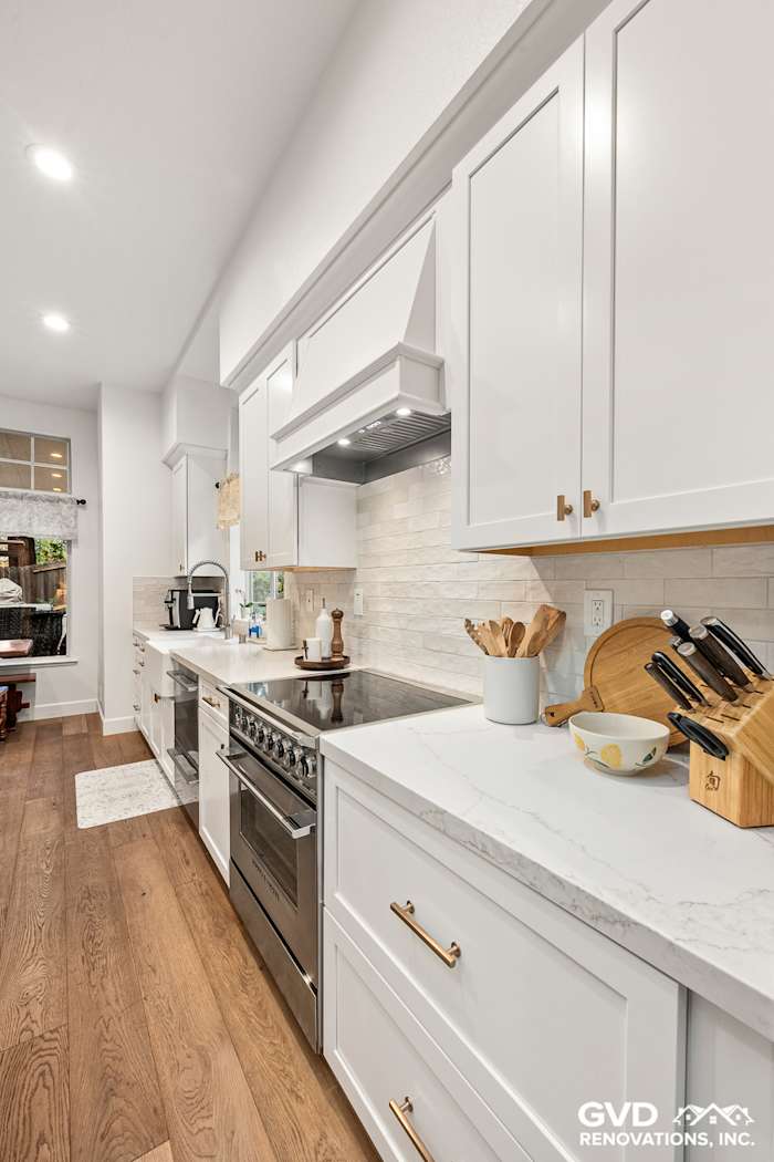 Sleek Folsom kitchen remodel featuring white Waypoint cabinets, custom Vadara Bronzo countertops, and hardwood floors