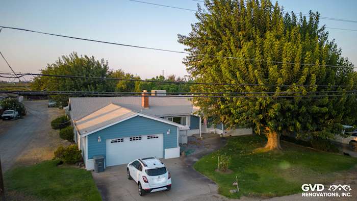 Yuba City home featuring new blue Alside Prodigy vinyl siding, surrounded by trees and driveway
