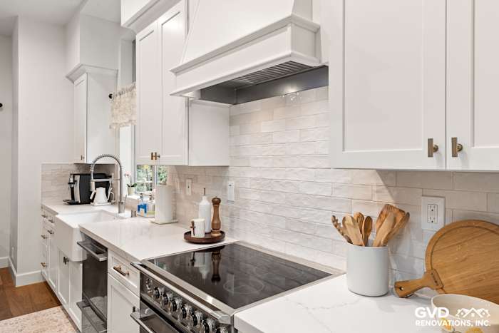Modern kitchen remodel featuring white Waypoint cabinets, Vadara Bronzo countertop, and stylish subway tile backsplash