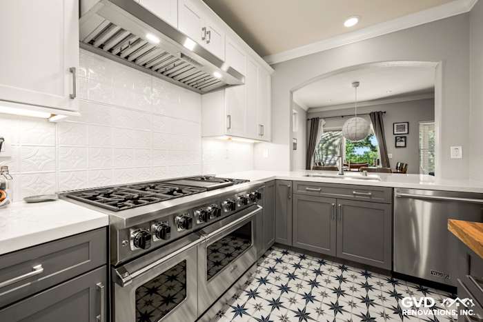 Modern kitchen with gray cabinetry, white subway tile backsplash, and distinctive blue star-patterned tile flooring