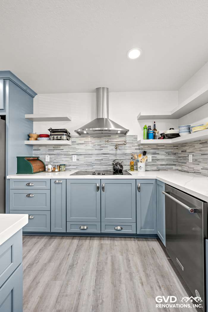 Modern kitchen with blue Waypoint cabinets, MSI Calacatta Ultra countertops, and Misty Fjord backsplash in Elk Grove