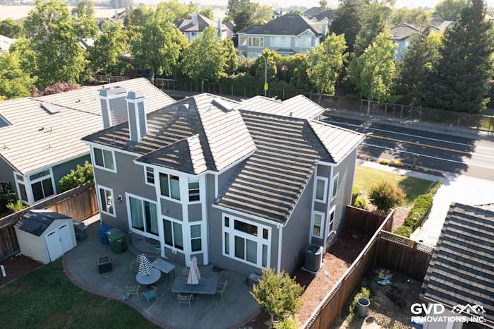Home exterior in Petaluma featuring James Hardie Aged Pewter siding and Alside Mezzo vinyl windows, surrounded by greenery