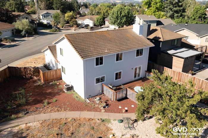 Updated home exterior with white James Hardie siding, new windows, and a deck in Petaluma