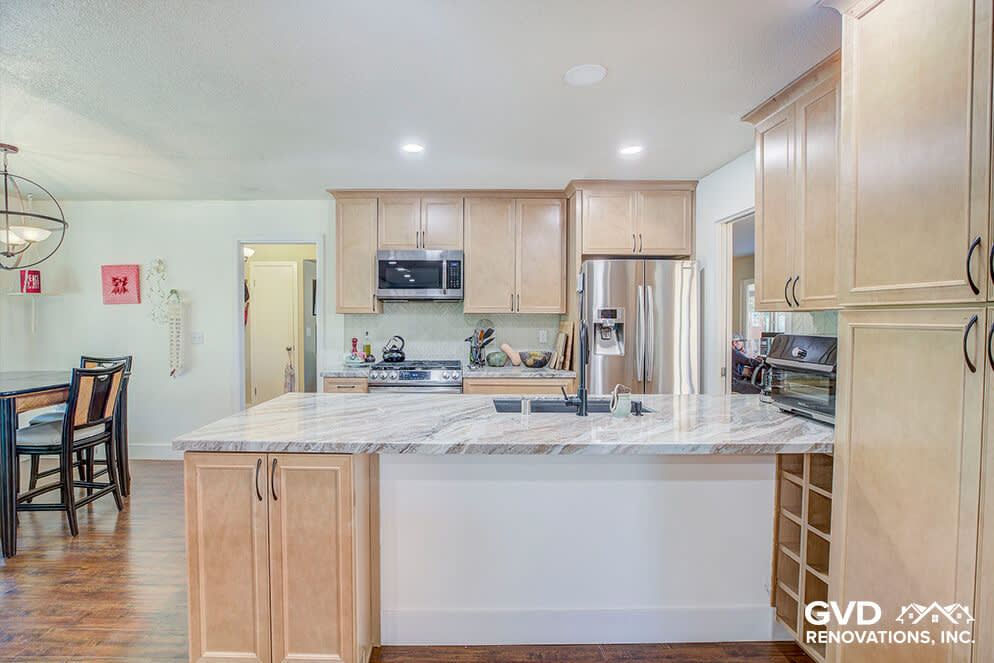 Modern kitchen featuring light wood cabinets, quartz countertops, and bright open layout
