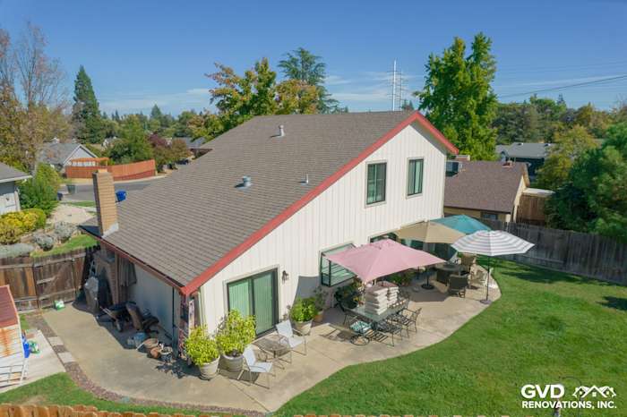 Home exterior in Orangevale featuring new T1-11 siding and Anlin windows, with patio and umbrellas visible
