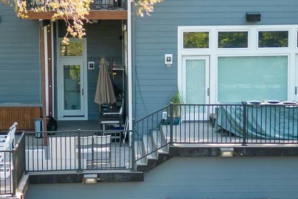 Home exterior featuring James Hardie Night Gray siding and Arctic White trim in Orinda, CA, with a deck and landscaped yard