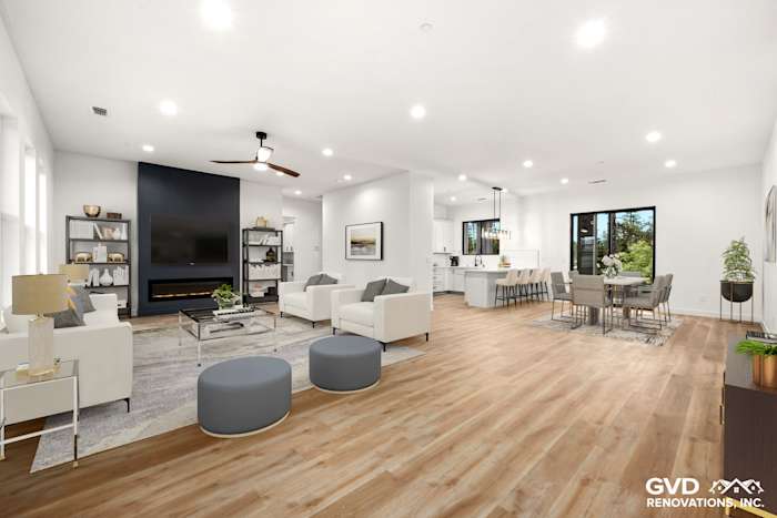 Spacious open-concept living area in new home construction, featuring high ceilings, modern furniture, and large windows