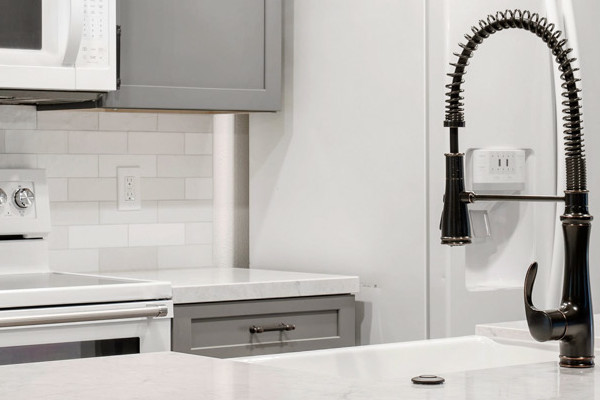 Modern kitchen remodel featuring gray cabinets, quartz countertop, and pendant lighting in Sacramento