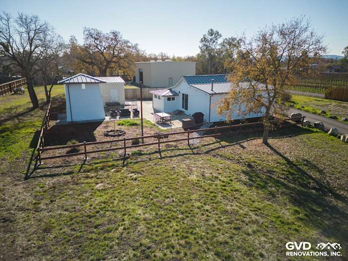 Home exterior featuring Arctic White James Hardie siding, surrounded by a green yard and wooden fence in Sonoma