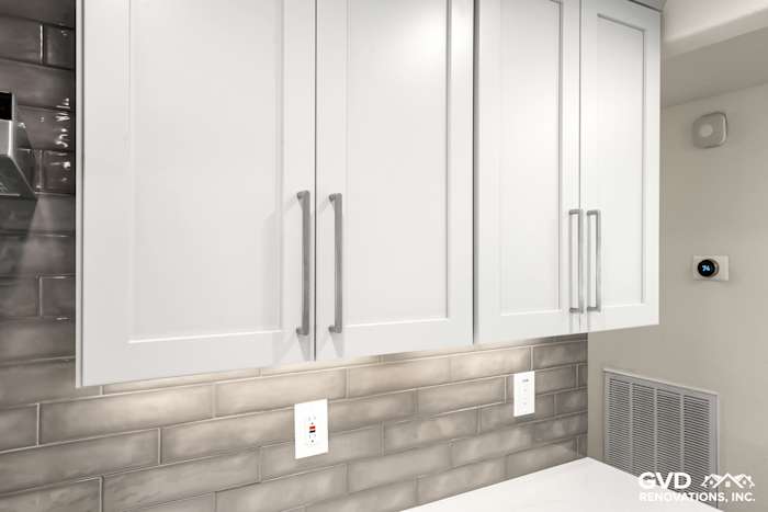 Sleek white kitchen cabinets with modern handles above gray subway tile backsplash in Rocklin remodel