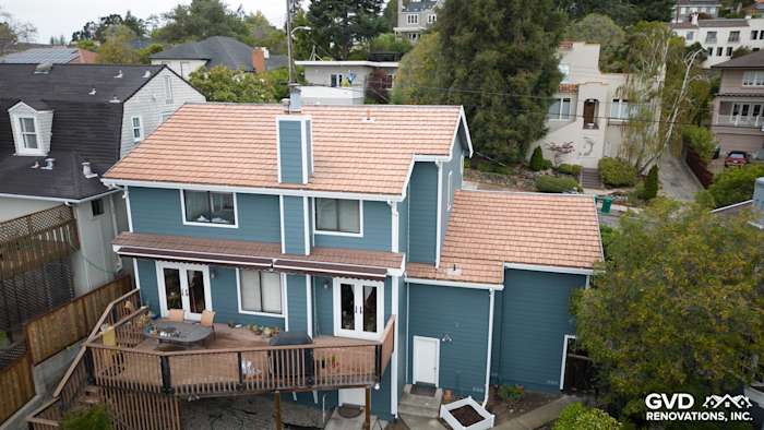Two-story home exterior featuring James Hardie Evening Blue siding, Rustic Grain Arctic White trim, and a wooden deck