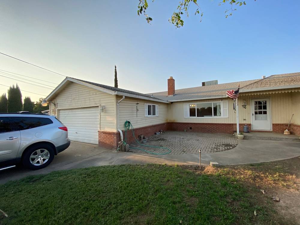 Single-story home exterior in Sacramento with a brick façade and paved driveway