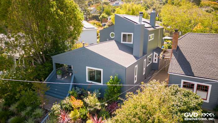 Corte Madera home exterior featuring James Hardie Evening Blue siding and Arctic White trim, surrounded by lush greenery