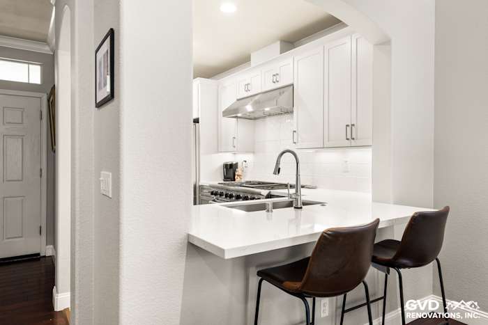 Modern Folsom kitchen remodel featuring white cabinets, quartz countertops, and a sleek bar area with seating