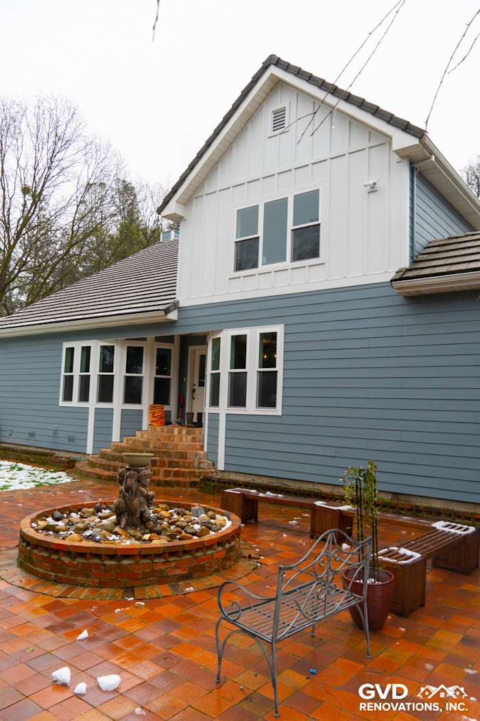 Home exterior featuring Boothbay Blue James Hardie siding and Milgard windows with a stone fountain and patio in Sutter Creek