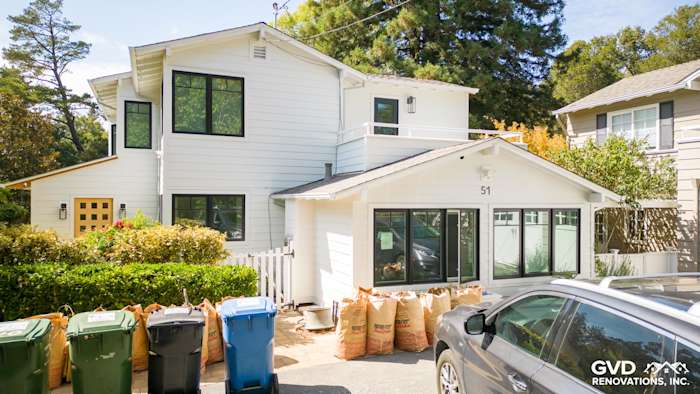 Modern home exterior showcasing Arctic White James Hardie siding and trim, featuring large windows and landscaped yard