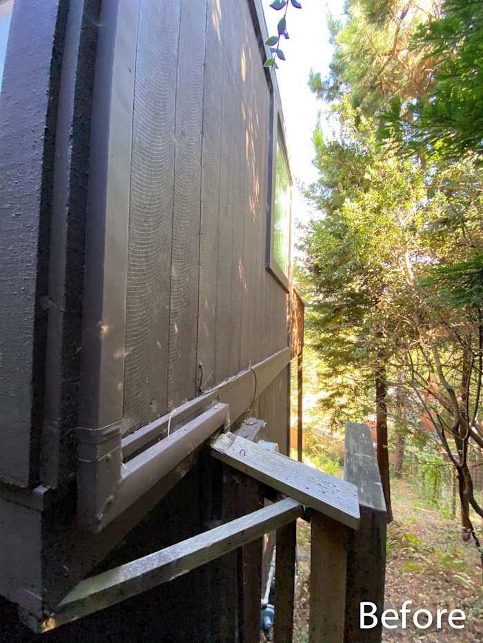 Before image of a home’s exterior featuring worn siding and an unrefined wooden staircase