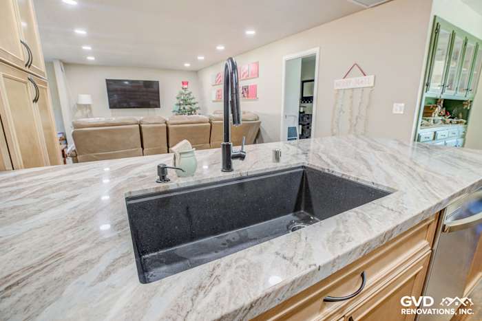 Modern kitchen sink with black quartz countertop and sleek faucet, view from island in Sacramento remodel