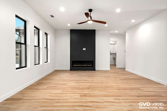 Open-concept living area with high ceilings, modern fireplace, and large windows in new construction home in Paradise, CA
