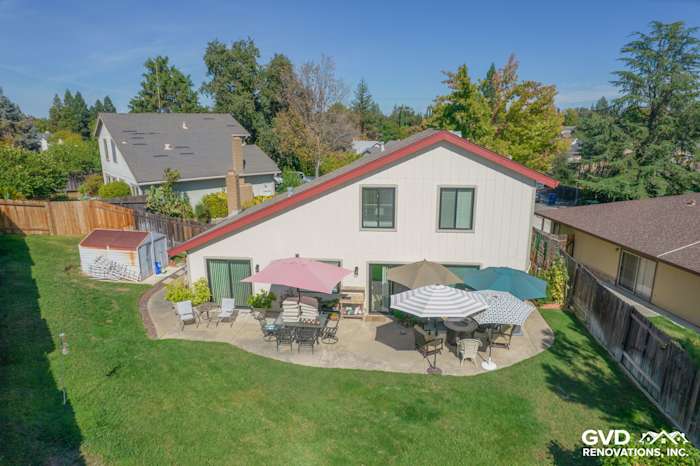 Backyard view of a home in Orangevale featuring T1-11 siding, patio seating, and Anlin windows