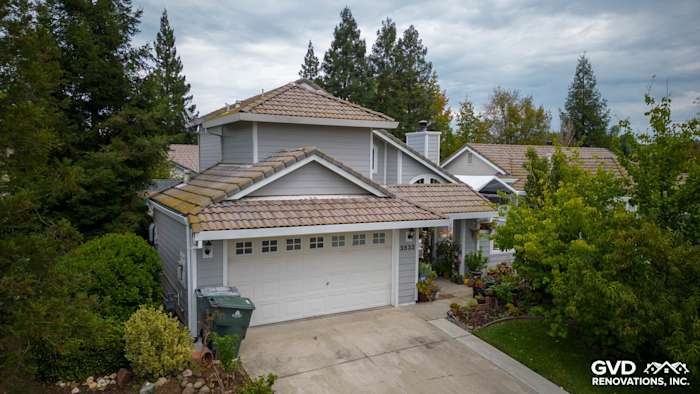 Home exterior in Rocklin featuring James Hardie Pearl Gray siding and Arctic White trim, surrounded by vibrant landscaping