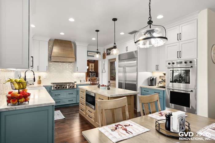Open kitchen with Fieldstone cabinetry, Denali White Quartzite countertops, and stylish pendant lighting
