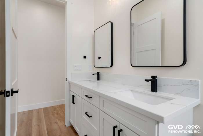 Modern bathroom with dual vanity, white cabinetry, quartz countertops, and black fixtures in Paradise, CA
