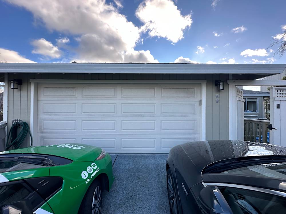 Two cars parked in front of a white garage with blue sky and clouds above, Sacramento
