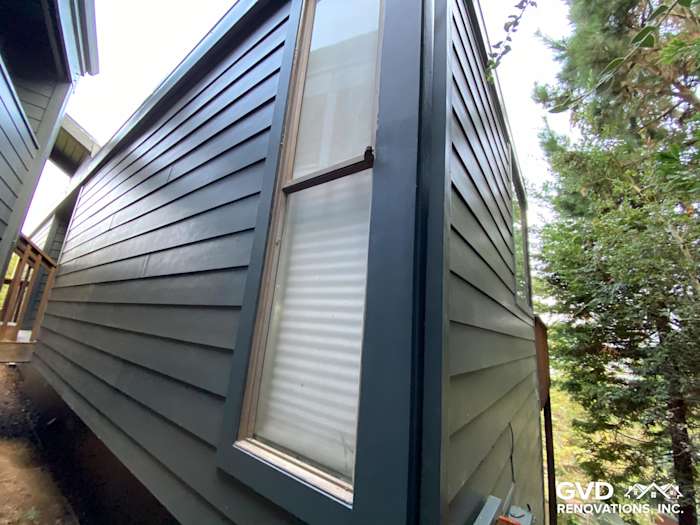 Vertical view of James Hardie siding in dark blue on a Mill Valley home with large windows