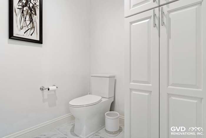 Bright bathroom with white cabinetry, modern toilet, and decorative wall art in Fair Oaks, CA
