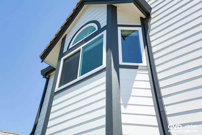 Arctic White James Hardie lap siding with Iron Gray trim on a home's upper exterior in Hayward, CA