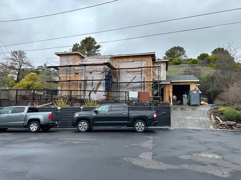 Residential home in Tiburon, CA with scaffolding, under renovation, surrounded by parking and greenery