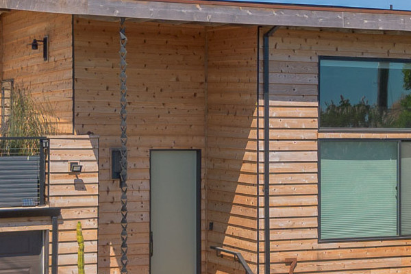 Natural cedar beveled plank siding on a modern home exterior with new deck railings in Richmond, CA