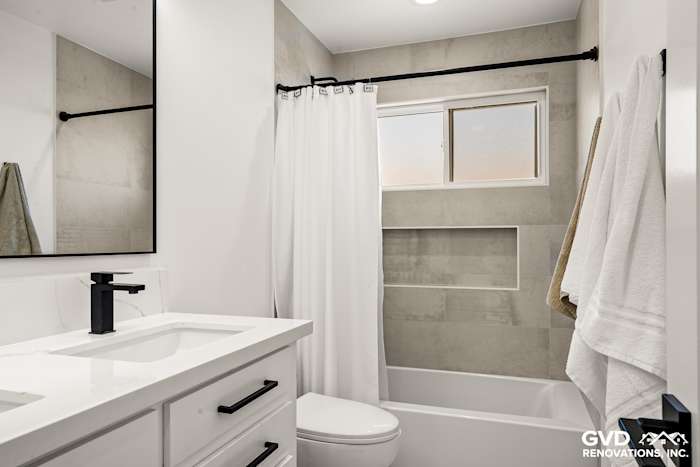 Modern bathroom featuring a freestanding tub, dual vanity, white tiles, and sleek fixtures in Antelope, CA