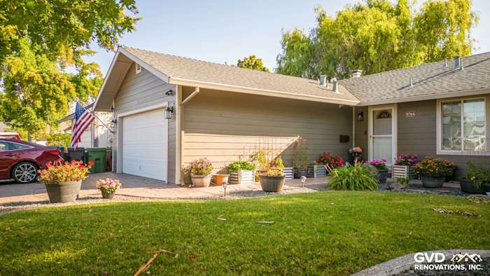 Modern home exterior featuring Timber Bark HardiePlank siding and Cobble Stone HardieTrim with colorful flower pots