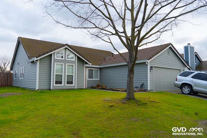 Updated home exterior featuring Prodigy Solid Core Insulated Siding in blue, with painted eaves and gutters