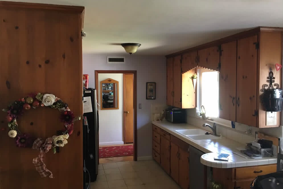 Old wooden cabinets and tile floors in a Sacramento kitchen with floral accents and suburban charm