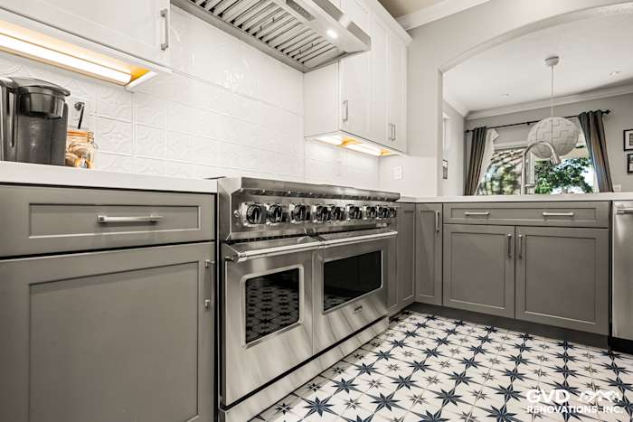 Modern kitchen featuring a stainless steel range, gray cabinetry, and decorative patterned tile flooring in Folsom, CA